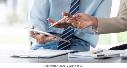 Business Consultants Reviewing Financial Reports on Tablet in Casual Cafe Setting - Powered by Shutterstock