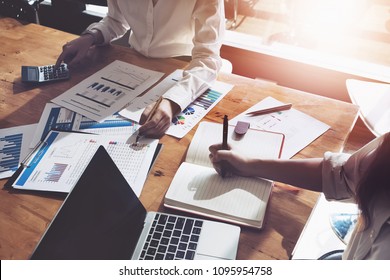 business consulting or finance budget plan, business advisor holding pen pointing to explain method profit with business owner use pen write to notebook and use laptop computer.