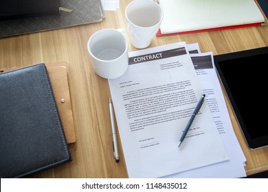 A business contract is placed on the executive desk. - Shutterstock ID 1148435012