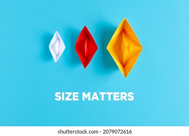 Business Corporate Or Company Size Decision Concept. Three Paper Boats With Different Size And Colors On Blue Background With The Text Size Matters.