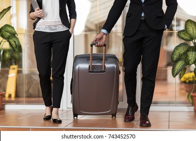 Business Couple In Hotel Lobby, Businesspeople Group Man And Woman Guests Arrive Entrance With Suitcase