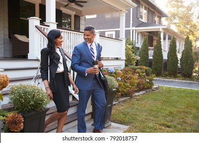 Business Couple Leaving Suburban House For Commute To Work