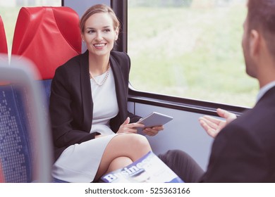 Business couple talking while traveling in train