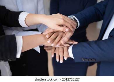 Business coworkers stacked hands close up. Team of office employees, workers making community pile of hands gesture, keeping teamwork, teambuilding, unity spirit, expressing engagement, respect