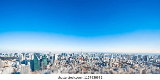 Business And Culture Concept - Panoramic Modern City Skyline Bird Eye Aerial View Under Dramatic Blue Sky In Tokyo, Japan. Miniature Lens Tilt Shift Blur Effect