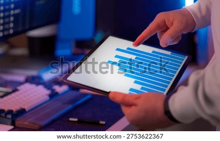 Business data dashboard tablet statistics comparison analysis. Analyst pointing bar chart digital report performance evaluation metrics review data interpretation decision support planning