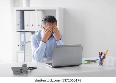 business, deadline and stress people concept - stressed businessman with laptop working at office