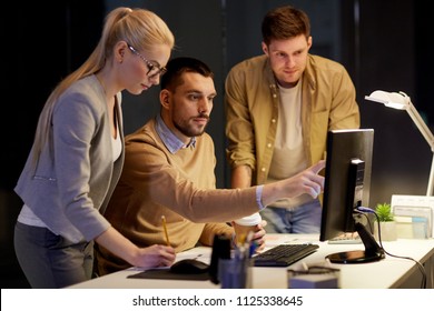 business, deadline and technology concept - coworkers with computer and takeout coffee working late at night office - Shutterstock ID 1125338645