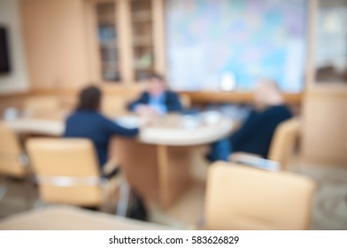 Business Debate In Office Interior. Men In Suits Sitting Near Table. Blur Abstract Background Of Employees. Business Meeting Room. Conference Discussion. People Use New Technology In Team. Boardroom