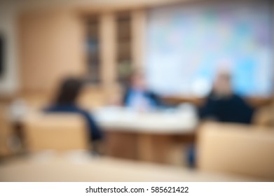 Business Debate In Office Interior. Men In Suits Sitting Near Table. Blur Abstract Background Of Employees. Business Meeting Room. Conference Discussion. People Use New Technology In Team. Boardroom