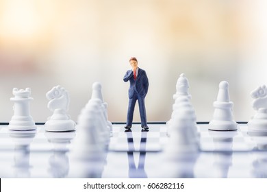 Business Decision Making Concept. Miniature People : Small Businessman Figure Standing And Walking On Chessboard With Chess Pieces