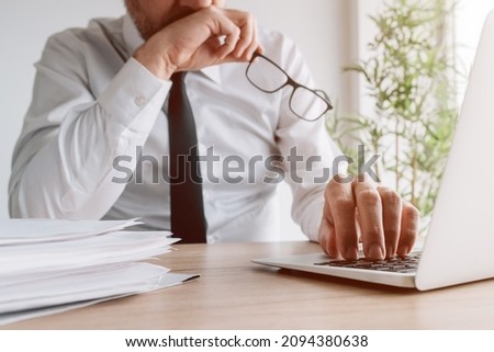 Business decision-making mistakes, businessman realizing wrong steps he had made while sitting at the office desk and using laptop, selective focus
