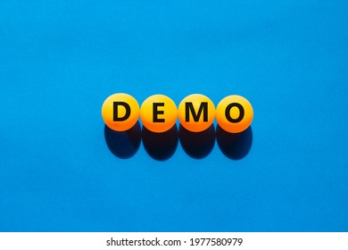 Business and demo symbol. Orange table tennis balls with the word 'demo'. Beautiful blue background, copy space. Business, demo concept.