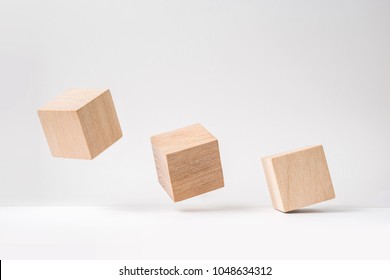 Business and design concept - abstract geometric real wooden cube with surreal layout on white floor background and it's not 3D render. It's the symbol of leadership, teamwork and growth