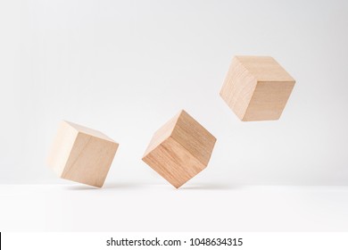 Business and design concept - abstract geometric real wooden cube with surreal layout on white floor background and it's not 3D render. It's the symbol of leadership, teamwork and growth