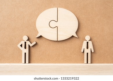 Business And Design Concept - Group Of Wooden Businessman Icon With Jigsaw Dialogue Frame On Kraft Paper. It's Conversation, Leadership Concept