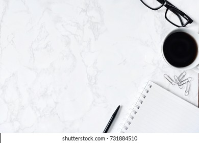 Business Desk Composition. Notebook, Pen, Glasses, Paperclip, Hot Coffee On Marble Table. Modern Workspace For Businessman Working Concept. Flat Lay, Top View. B&W Tone. Copy Space.