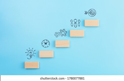Geschäftsentwicklungsstrategie, Aktionsplan und Zielkonzepte, Holzwürfel-Staffelung als Stufentreppe mit Ikonen-Geschäftsstrategie auf blauem Hintergrund. Kopienraum