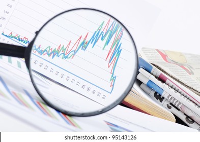 Business diagramme with magnifying glass, workplace businessman - Powered by Shutterstock