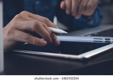 Business, digital technology, social network concept. Close up of business man, graphic designer with stylus pen touching on digital tablet, working on laptop computer in office, connecting internet - Shutterstock ID 1481933354