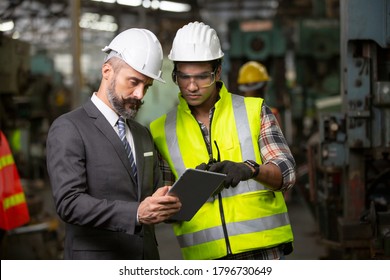 Business Director And Mechanic Engineer Checking And Discussing At Factory Shop Floor.