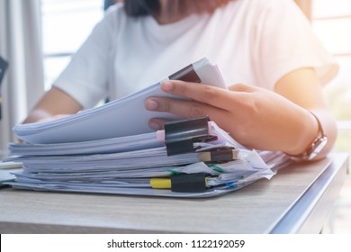 Konzept der Unternehmenspapiere: Die Mitarbeiterinnen, die in Papierstapeln arbeiten, um unfertiges Dokument zu durchsuchen und zu überprüfen, erreichen bei Papierdokumenten am Arbeitsbüro die Arbeit. Weichfokus