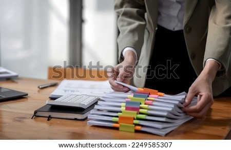 Business Documents concept, woman hands working on Stacks paper files for checking document achieves on folders papers at office.