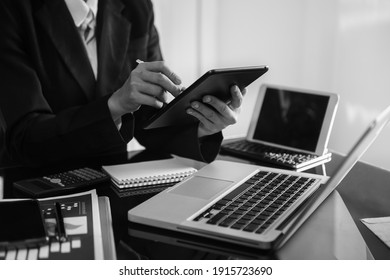 Business Documents On Office Table With Smart Phone And Digital Tablet And Graph Financial And Man Working Black And White