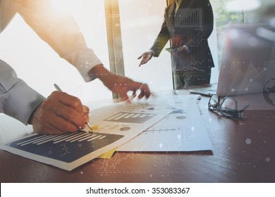 business documents on office table with smart phone and laptop computer and graph finance with social network diagram and two colleagues discussing data in the background - Shutterstock ID 353083367