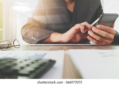 business documents on office table with digital tablet computer with smart phone and graph finance diagram and businessman working in the background - Shutterstock ID 366977075
