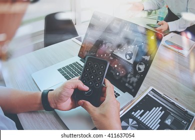 business documents on office table with smart phone and laptop computer and graph finance with social network diagram and two colleagues discussing data in the background

 - Shutterstock ID 411637054