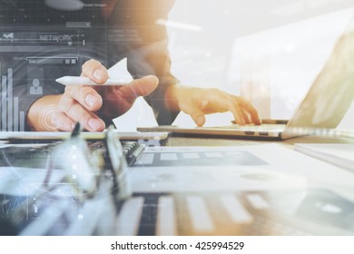 business documents on office table with laptop computer and smart phone and graph finance digital diagram and businessman working in the background - Shutterstock ID 425994529