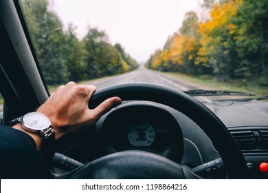 Business Driver Driving A Car On A Forest Autumn Road. Late, Hurry, Hours.