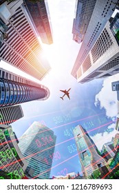 Business Economy Concept Showing Stock Market Ticker On Modern Office Skyscraper Buildings In Singapore's Business And Financial District With Plane Overhead. Vertical Orientation.