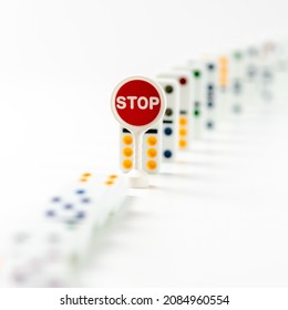 Business And Economy Dominoes Concept. Falling Dominos Pieces Stopped By Text STOP. Chain Reaction And Domino Effect