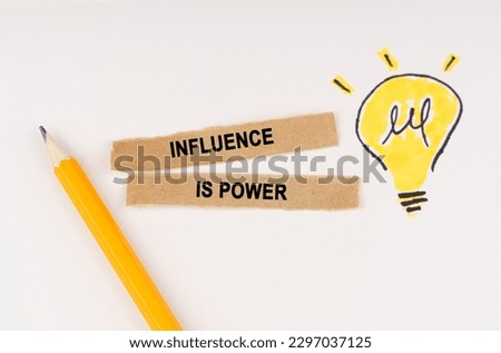 Business and education concept. A luminous light bulb is drawn on a white background, next to it lies a pencil and pieces of paper with the inscription - influence is power