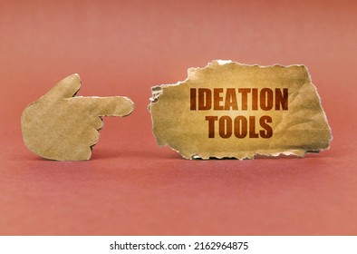 Business And Education Concept. On A Brown Surface, A Cardboard Hand Points To A Sign That Says - Ideation Tools