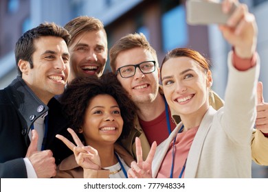 Business, Education And Corporate Concept - International Group Of People With Smartphone Taking Selfie On City Street And Showing Peace Hand Sign