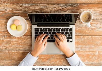 Business, Education, People And Technology Concept - Close Up Of Female Hands With Laptop Computer, Cookies And Coffee Cup On Table