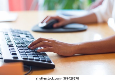 business, education, programming, people and technology concept - close up of african american female hands typing on keyboard and using mouse