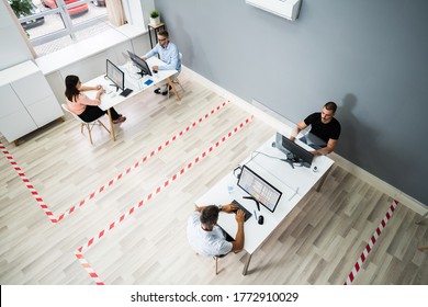 Business Employee Social Distancing Using Sneeze Guards In Office