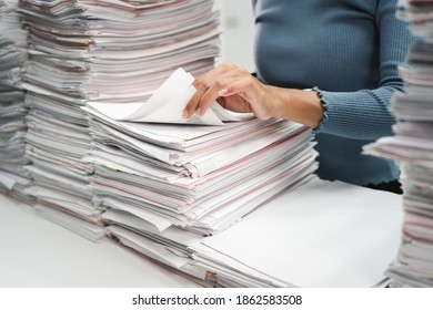 Business employee woman working in stacks paper files for checking unfinished achieves busy at work. - Shutterstock ID 1862583508