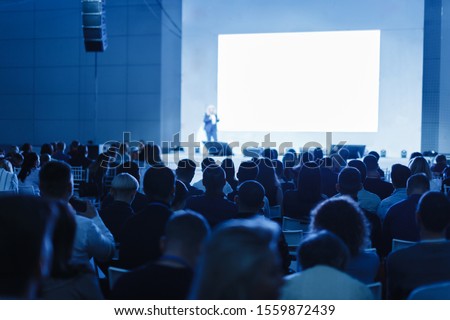 Business and Entrepreneurship concept. Speaker giving a talk in conference hall at business event. Audience at the conference hall. Focus on unrecognizable people