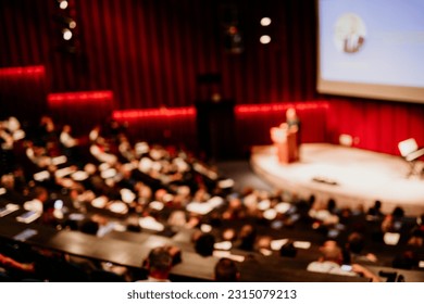 Business and entrepreneurship symposium. Female speaker giving a talk at business meeting. Audience in conference hall. Rear view of unrecognized participant in audience. - Shutterstock ID 2315079213
