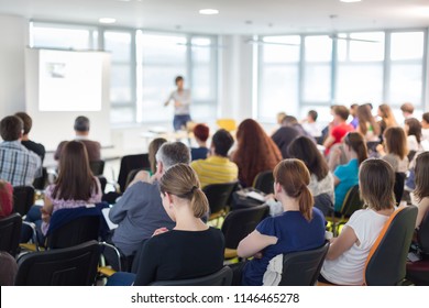 Business and entrepreneurship symposium. Speaker giving a talk at business meeting. Audience in conference hall. Rear view of unrecognized participant in audience. - Shutterstock ID 1146465278