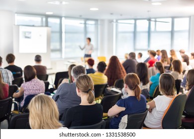 Business and entrepreneurship symposium. Speaker giving a talk at business meeting. Audience in conference hall. Rear view of unrecognized participant in audience. - Shutterstock ID 1331538500