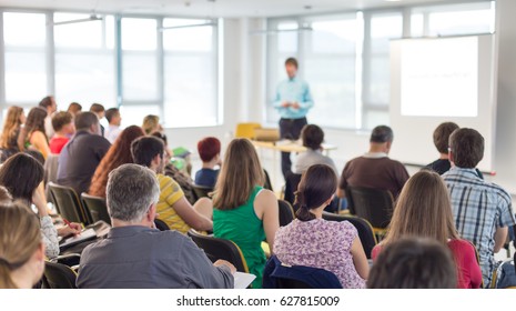 Business and entrepreneurship symposium. Speaker giving a talk at business meeting. Audience in conference hall. Rear view of unrecognized participant in audience. - Shutterstock ID 627815009