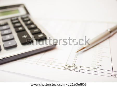 business environment. gray ballpoint pen, printed document and a large calculator on the table. Closeup.