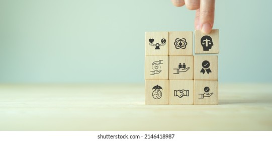 Business ethics concept. Ethics inside human mind. Business integrity and moral. Putting wooden cubes with ethics inside a head standing with other ethics icon. Company culture and sustainable success - Shutterstock ID 2146418987