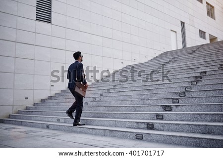 Business executive with briefcase going up the stairs